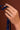 Hand wearing an Asscher cut diamond engagement ring, holding a Royal Asscher navy ribbon against a brown background.