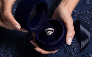Royal Asscher Oval three stone ring with oave wedding band is placed in blue velvet Royal Asscher engagement box.