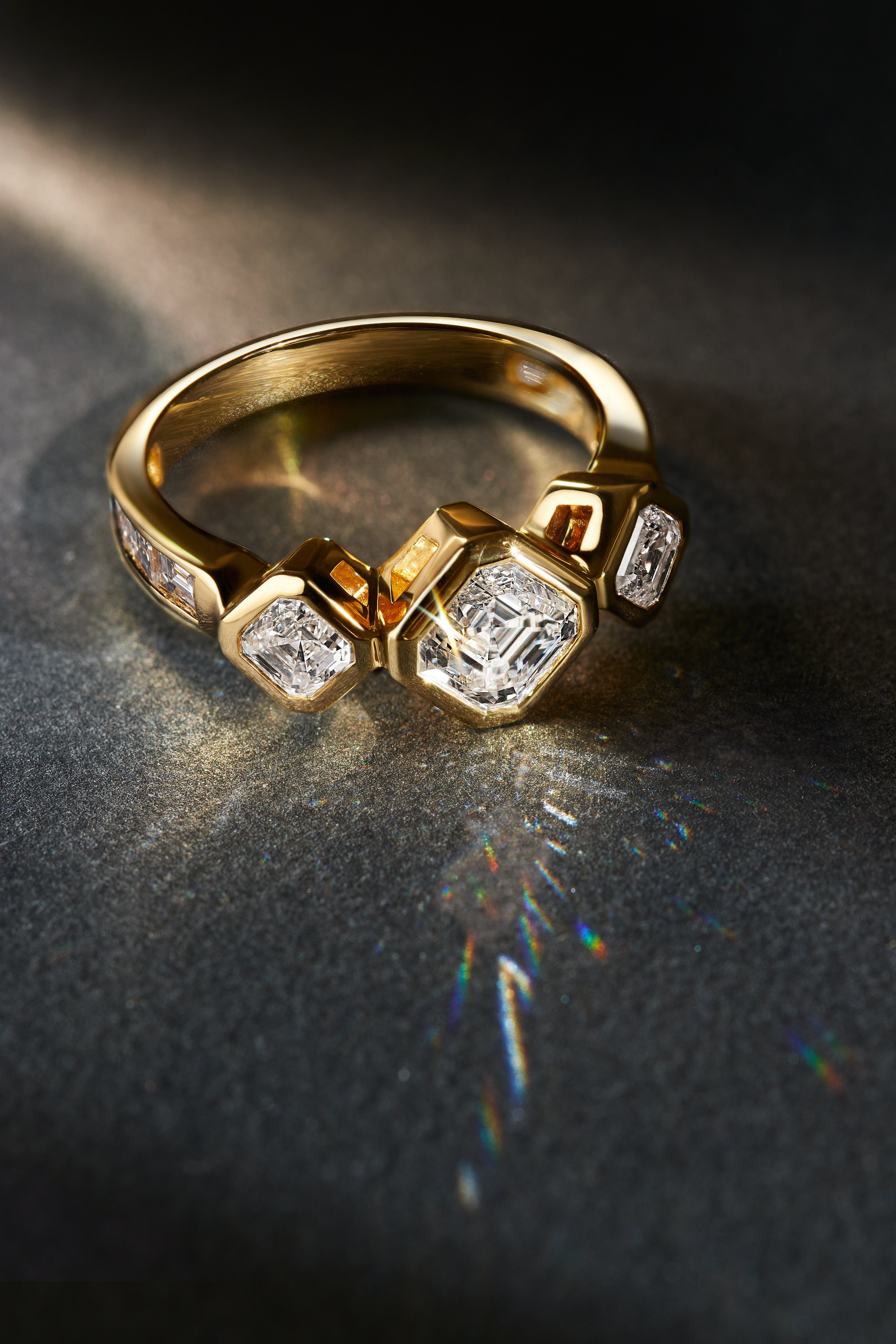 Royal Asscher Cut bezel engagement ring with three stones in 18k yellow gold